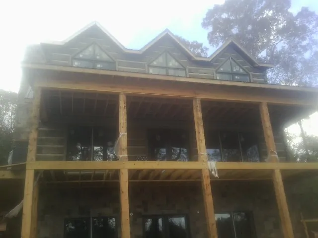 Dormers and porch framing on a large log home under construction — Roof Coating work by our crew in Porter Ranch