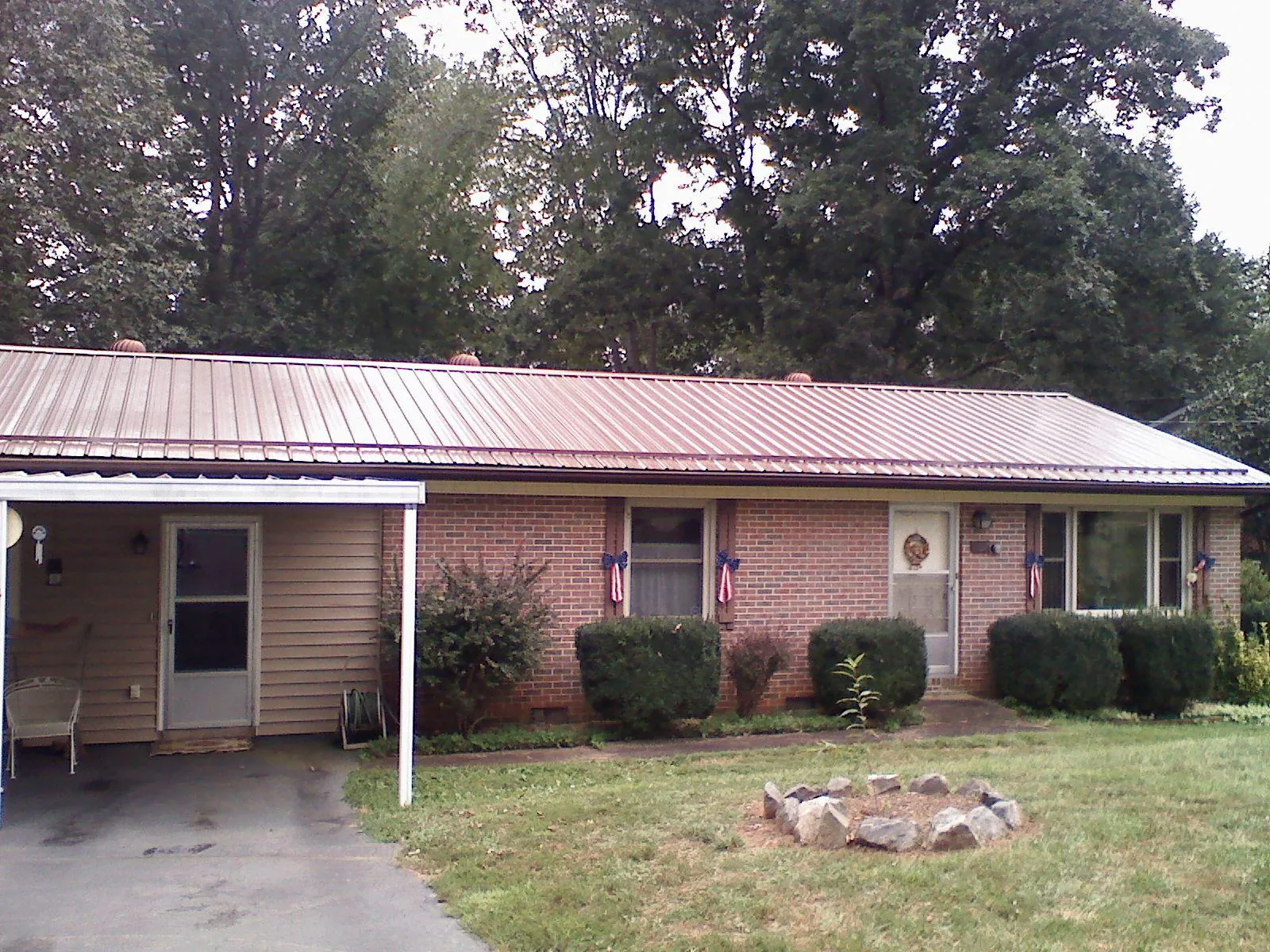 Bronze metal roof and carport on a brick ranch home — Roof Repair work by our crew in Porter Ranch
